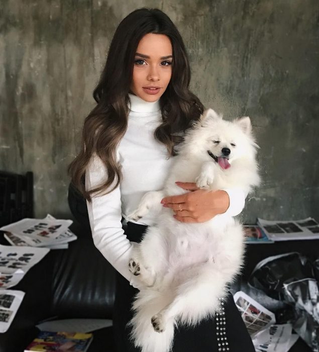 מאשה ווי מחזיקה כלב בזרועותיה.