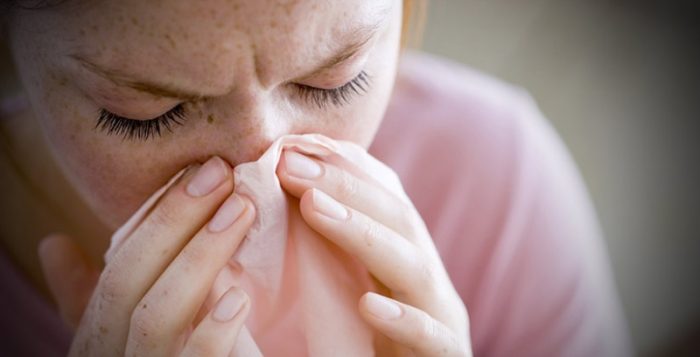 אישה מתעטשת