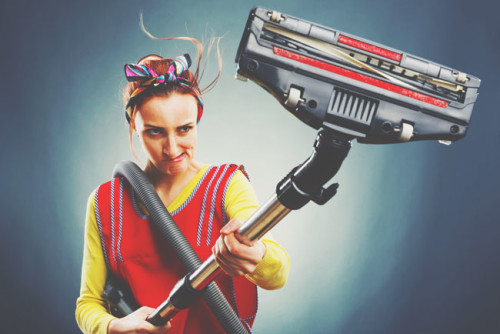 ילדה באפוד אדום אוחזת בשואב אבק