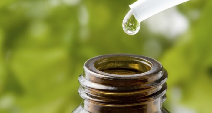 טיפת שמן נופלת מטפטפת לתוך בקבוק