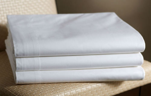 שלושה סדינים מקופלים על כיסא